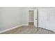 Bedroom features gray vinyl plank flooring, an entry door, and a white closet at 1317 Ravida Woods Dr, Apopka, FL 32703