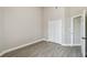 Light filled bedroom with gray vinyl floors, closet, neutral color paint and an entry door at 1317 Ravida Woods Dr, Apopka, FL 32703