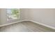 Neutral bedroom with wood-look vinyl floors, window with blinds, and white trim and baseboards at 1317 Ravida Woods Dr, Apopka, FL 32703