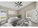 Comfortable bedroom with vaulted ceiling, large windows, a ceiling fan and modern decor at 1317 Ravida Woods Dr, Apopka, FL 32703