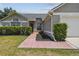 Home with a cozy entrance, manicured bushes, and a red brick walkway, enhancing its curb appeal at 1317 Ravida Woods Dr, Apopka, FL 32703