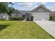 Charming home features a well-manicured lawn, lush shrubs, and a two-car garage, offering great curb appeal at 1317 Ravida Woods Dr, Apopka, FL 32703