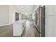 Modern kitchen with stainless steel refrigerator and a large white island that opens into the living area at 1317 Ravida Woods Dr, Apopka, FL 32703