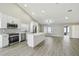 Bright modern kitchen with stainless steel appliances and gray backsplash that opens into a dining and living area at 1317 Ravida Woods Dr, Apopka, FL 32703