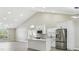 Bright kitchen with white cabinets, gray backsplash, stainless steel appliances, and large island that opens into the living room at 1317 Ravida Woods Dr, Apopka, FL 32703