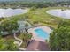 Aerial view of community pool, tennis courts, clubhouse and two lakes at 1317 Ravida Woods Dr, Apopka, FL 32703