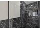 Close-up of the modern shower area, featuring striking black marble-patterned tile at 1317 Ravida Woods Dr, Apopka, FL 32703