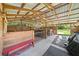 View inside the barn featuring wooden stalls, a red bench, and a metal-roofed ceiling at 13232 Ne 39Th Ter, Anthony, FL 32617