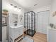 Modern bathroom features a black-framed shower, a white vanity and ample cabinet storage at 13232 Ne 39Th Ter, Anthony, FL 32617