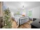 Bright bedroom features wood floors, a modern light fixture, a wrought iron bed frame, and plenty of natural light at 13232 Ne 39Th Ter, Anthony, FL 32617