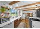 Charming kitchen features wood cabinets, modern appliances, wood beams, and views of the dining area at 13232 Ne 39Th Ter, Anthony, FL 32617