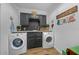 Laundry room with gray cabinetry, a stylish sink and modern washer and dryer units at 13232 Ne 39Th Ter, Anthony, FL 32617