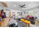 Large living room with comfortable black sofa, ceiling fan and plentiful natural light from the window at 13232 Ne 39Th Ter, Anthony, FL 32617