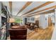 Spacious living room showcasing wood beams, hardwood floors, and comfortable leather seating at 13232 Ne 39Th Ter, Anthony, FL 32617