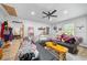 Large living room with comfortable black sofa, ceiling fan and plentiful natural light from the window at 13232 Ne 39Th Ter, Anthony, FL 32617