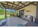 Covered porch with wood floors, sofa, bench and green backyard views at 13232 Ne 39Th Ter, Anthony, FL 32617