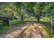 Gated driveway leading to a secluded residence with mature trees providing ample shade at 13232 Ne 39Th Ter, Anthony, FL 32617