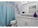 Bright bathroom featuring stylish decor, updated white cabinets, a toilet and shower with a blue curtain at 13618 Sw 111Th Cir, Dunnellon, FL 34432