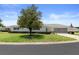 Charming single-story home featuring a well-manicured lawn, mature tree, and attached two-car garage at 13618 Sw 111Th Cir, Dunnellon, FL 34432