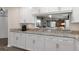 Bright kitchen with white cabinets, stone counters and stainless steel appliances and hardwood floors at 13618 Sw 111Th Cir, Dunnellon, FL 34432