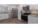 This kitchen features stainless steel appliances, white cabinets, and stone countertops at 13618 Sw 111Th Cir, Dunnellon, FL 34432