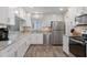 Modern kitchen with stainless steel appliances, white cabinets, and light stone countertops at 13618 Sw 111Th Cir, Dunnellon, FL 34432