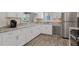 Bright kitchen features white cabinets, stainless appliances, stone countertops, and hardwood floors at 13618 Sw 111Th Cir, Dunnellon, FL 34432