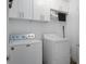Bright laundry room featuring modern appliances and overhead storage cabinets at 13618 Sw 111Th Cir, Dunnellon, FL 34432