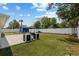 Spacious backyard featuring a concrete patio, a blue shed, grill, and a well-maintained lawn with a white fence at 14118 Sw 32Nd Terrace Rd, Ocala, FL 34473