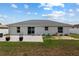 Backyard showcasing a concrete patio, sliding glass doors, and well-kept lawn, creating a relaxing outdoor space at 14118 Sw 32Nd Terrace Rd, Ocala, FL 34473