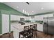Contemporary kitchen featuring white cabinets, stainless steel appliances, and an island with bar stools at 14118 Sw 32Nd Terrace Rd, Ocala, FL 34473