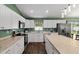 Spacious kitchen with stainless appliances, white cabinetry, island with seating, and wood flooring at 14118 Sw 32Nd Terrace Rd, Ocala, FL 34473