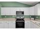 Well-lit kitchen with white cabinetry, stainless steel microwave and range oven at 14118 Sw 32Nd Terrace Rd, Ocala, FL 34473