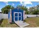 The backyard features a charming blue shed with white trim, and a wooden ramp for easy access at 14118 Sw 32Nd Terrace Rd, Ocala, FL 34473
