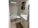 Bright bathroom with tub, toilet and sink with vanity and updated fixtures and shelving at 14121 Nw Highway 225, Reddick, FL 32686
