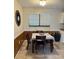 Dining room with wood paneled walls, wooden table and chairs and large window at 14121 Nw Highway 225, Reddick, FL 32686