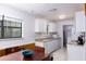 Bright kitchen features white cabinetry, tile flooring, wood-look accents, and a dining area by the window at 14121 Nw Highway 225, Reddick, FL 32686