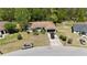 Aerial view of home with brown roof and car in driveway, surrounded by trees and neighboring homes at 15920 Sw 49Th Court Rd, Ocala, FL 34473