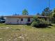 Backyard featuring a small door, AC unit, and lush greenery at 15920 Sw 49Th Court Rd, Ocala, FL 34473
