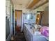 Outdated bathroom with a vanity, a mirror, floral wallpaper and a partial view of the shower behind a glass door at 15920 Sw 49Th Court Rd, Ocala, FL 34473