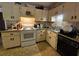 This kitchen features tile countertops, upper and lower cabinets, a white oven, and a black dishwasher at 15920 Sw 49Th Court Rd, Ocala, FL 34473
