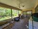 Spacious screened-in patio with comfortable seating and natural light, overlooking a backyard at 15920 Sw 49Th Court Rd, Ocala, FL 34473