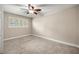 This bedroom features neutral walls, carpeted flooring, a ceiling fan, and a window providing natural light at 1640 Ne 40Th Ave # 107, Ocala, FL 34470