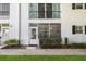 Two-story condo building with large screened window, white siding, and manicured landscaping at 1640 Ne 40Th Ave # 107, Ocala, FL 34470