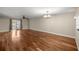 Spacious living room with hardwood floors, ceiling fan, a decorative chandelier, and sliding glass doors to a patio at 1640 Ne 40Th Ave # 107, Ocala, FL 34470