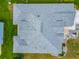 Aerial view of a home with a gray shingled roof, manicured landscaping and an American flag in the front yard at 16954 Se 93Rd Cuthbert Cir, The Villages, FL 32162