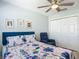 Bright bedroom with floral bedding, ceiling fan, closet and blue accent chair at 16954 Se 93Rd Cuthbert Cir, The Villages, FL 32162
