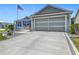 Charming home featuring blue shutters, a two-car garage, and a well-manicured yard with an American flag at 16954 Se 93Rd Cuthbert Cir, The Villages, FL 32162