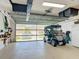 Clean garage featuring epoxy floors, golf cart, and overhead storage at 16954 Se 93Rd Cuthbert Cir, The Villages, FL 32162