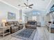 Spacious living room with plush reclining furniture, a ceiling fan, and large window providing ample natural light at 16954 Se 93Rd Cuthbert Cir, The Villages, FL 32162